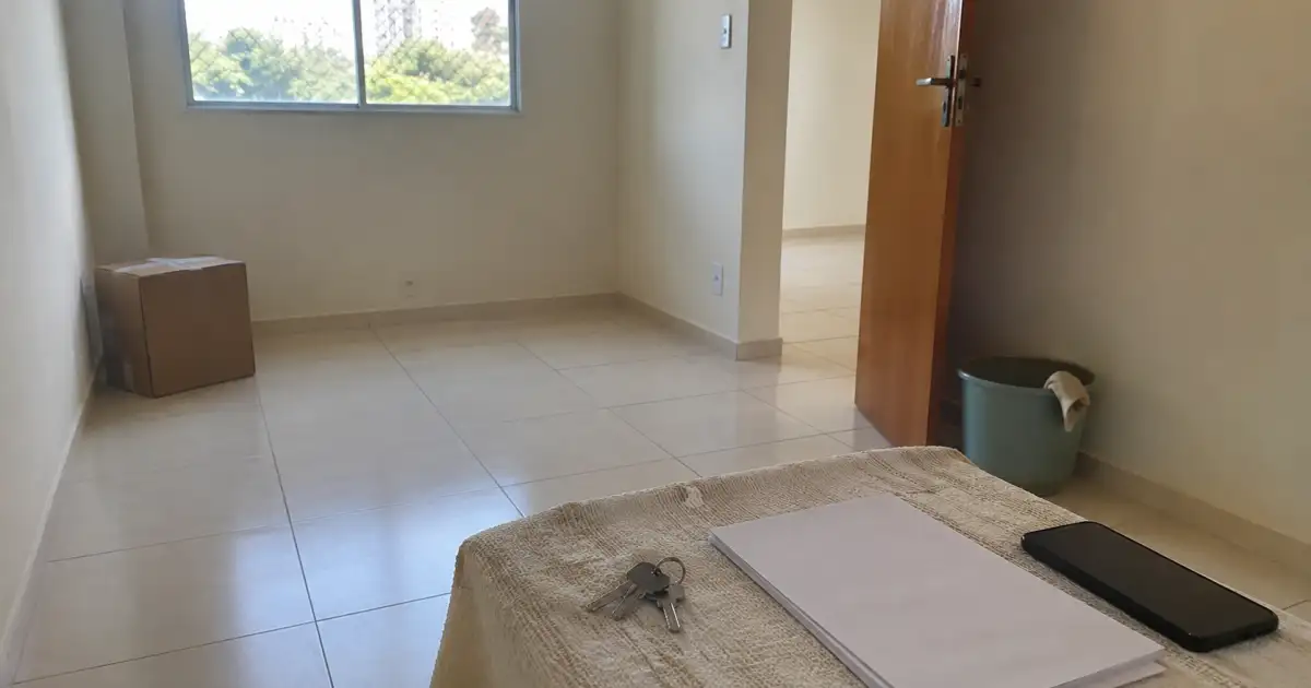 apartamento alugado quase vazio com caixas chaves checklist e materiais de limpeza para vistoria final
