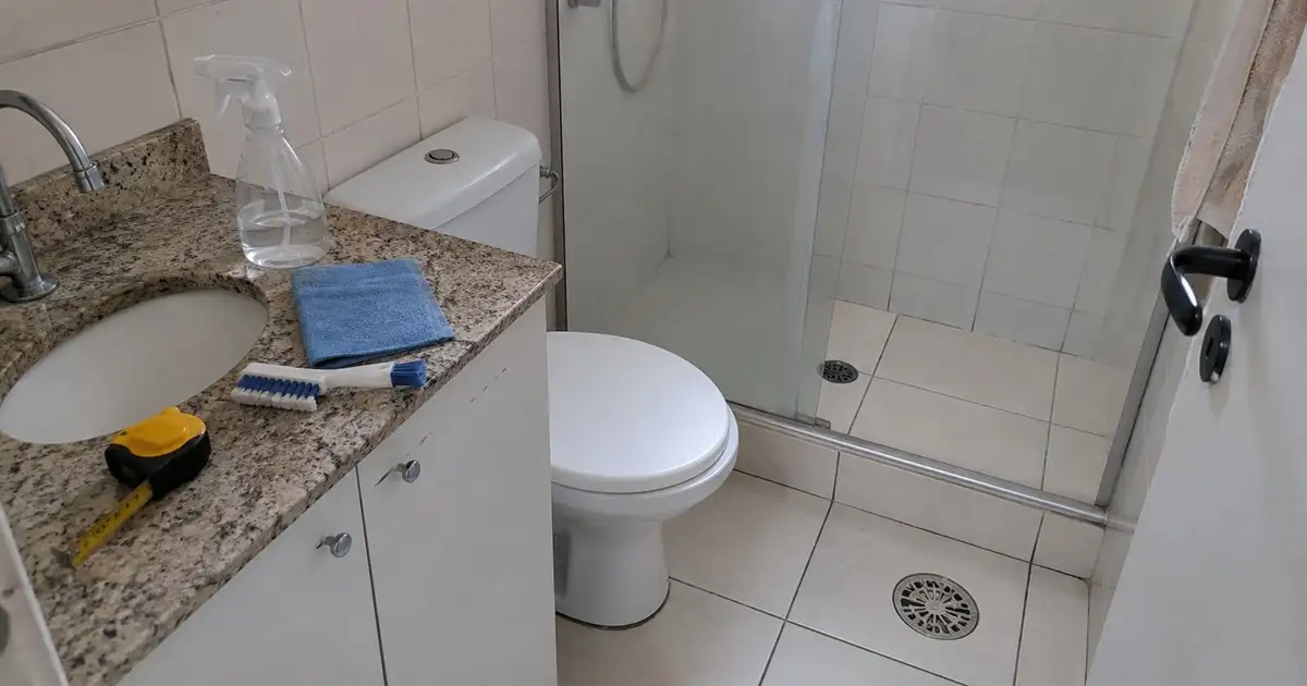 banheiro de apartamento alugado em avaliação com trena pano e borrifador sobre a bancada