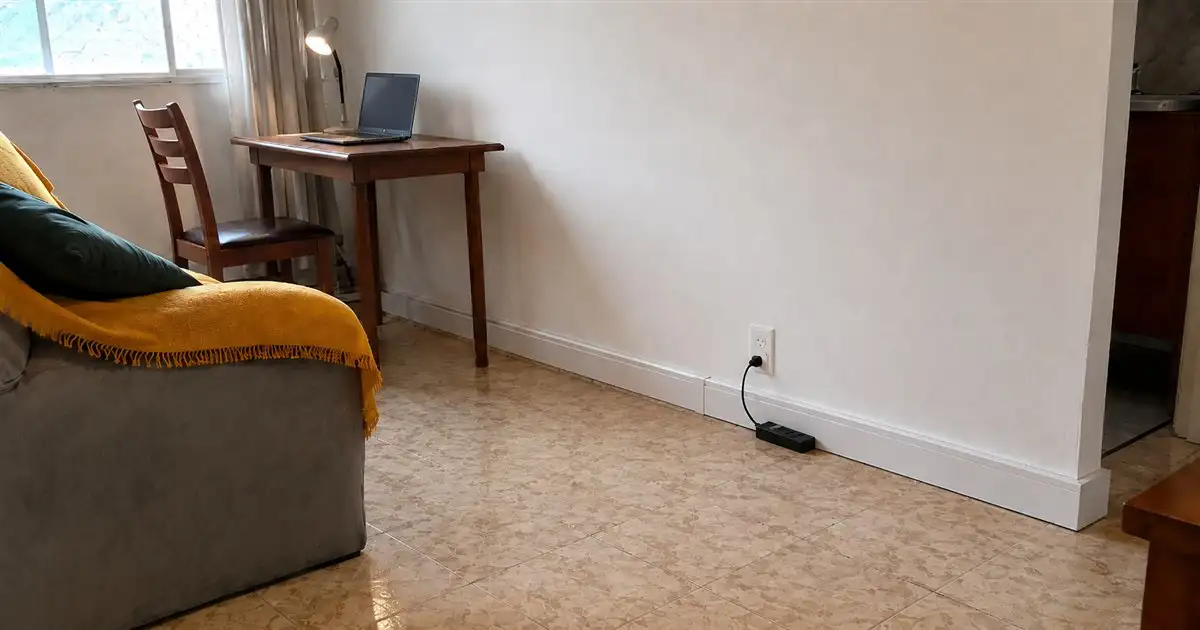 filtro de linha perto de tomada baixa com cabo curto em sala de apartamento alugado