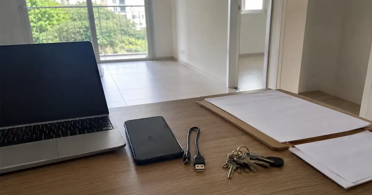 organização de fotos de vistoria de entrada em mesa com celular notebook e folha em branco