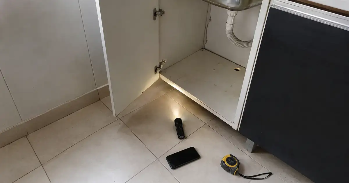 registro de detalhe em armario sob pia e rodape durante vistoria de entrada