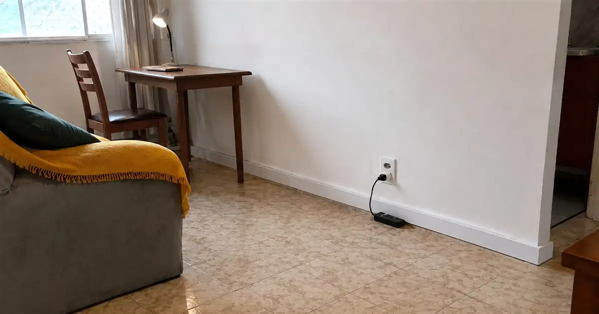 tomada baixa fora do ponto ideal em sala de apartamento alugado com filtro de linha no rodape